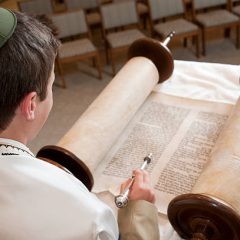 A young man reads the Torah.